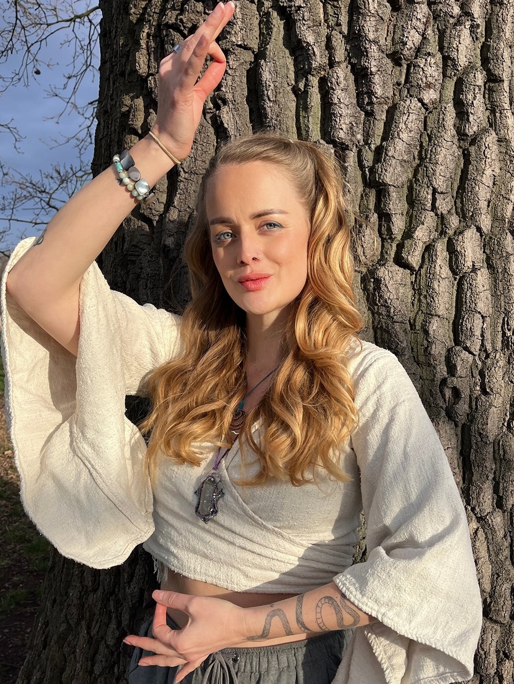 Maia sitting by a bright window, chin resting on her hand, looking directly at the camera